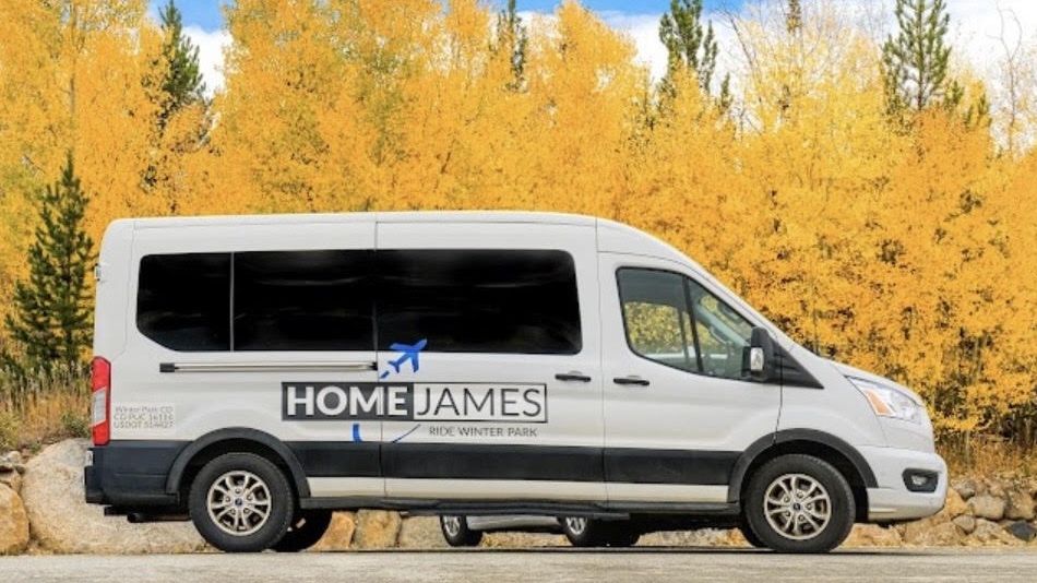 A Home James shuttle van in front of golden aspens